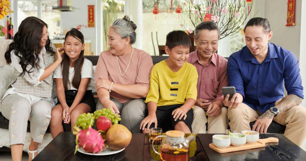 Multi-generational family gathered during Lunar New Year celebration at home, sharing food and conversation to nurture emotional balance and connection