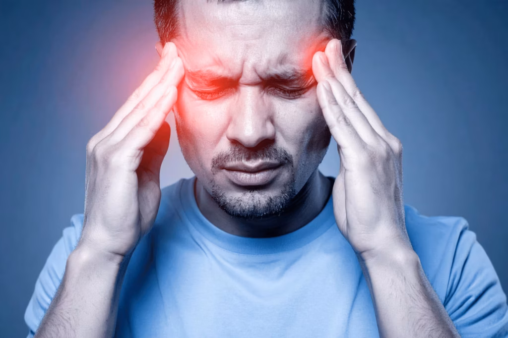 Man holding his temples while experiencing migraine pain and headache pressure