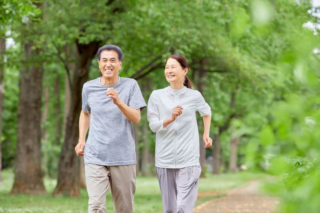 Two older adults walking outdoors in a green park to support cardiovascular health and healthy cholesterol levels_converted